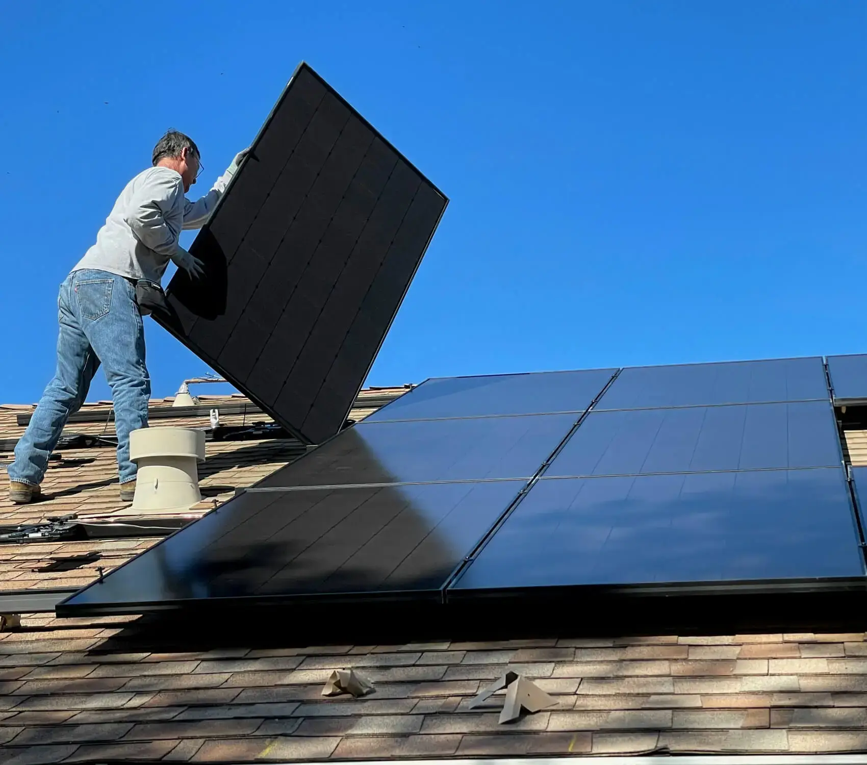 Un couvreur posant des paneaux solaires sur un toit
